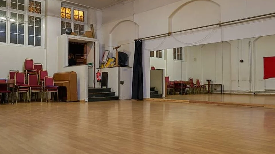 Dance studio interior with wooden floor and mirrors