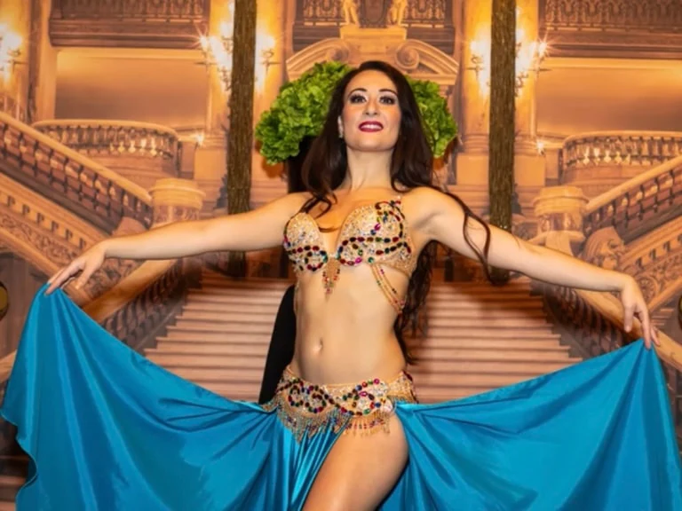 Belly dancer in blue costume performing on stage