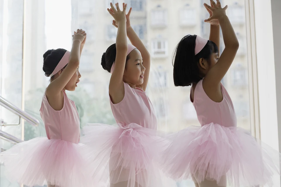 Three young ballet dancers in pink tutus
