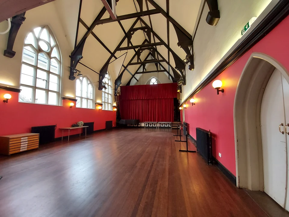 Dance studio with wooden floor and red walls