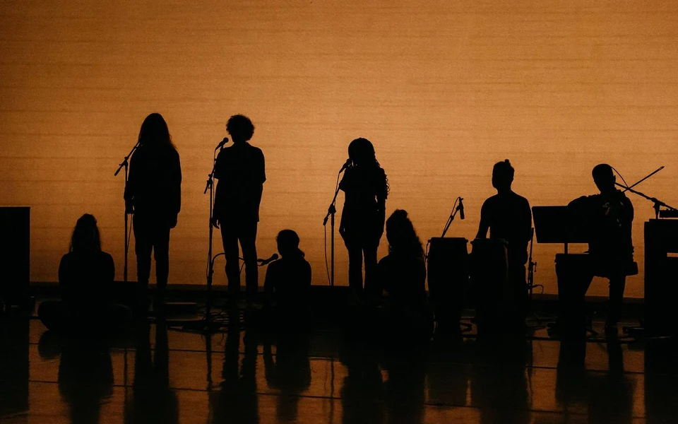 Silhouettes of performers on stage with instruments