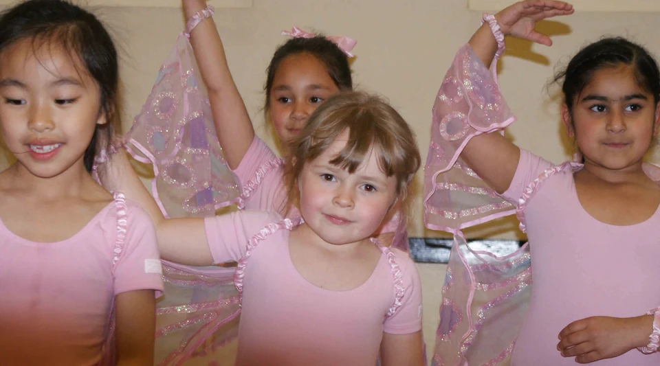 Young dancers in pink costumes with wings