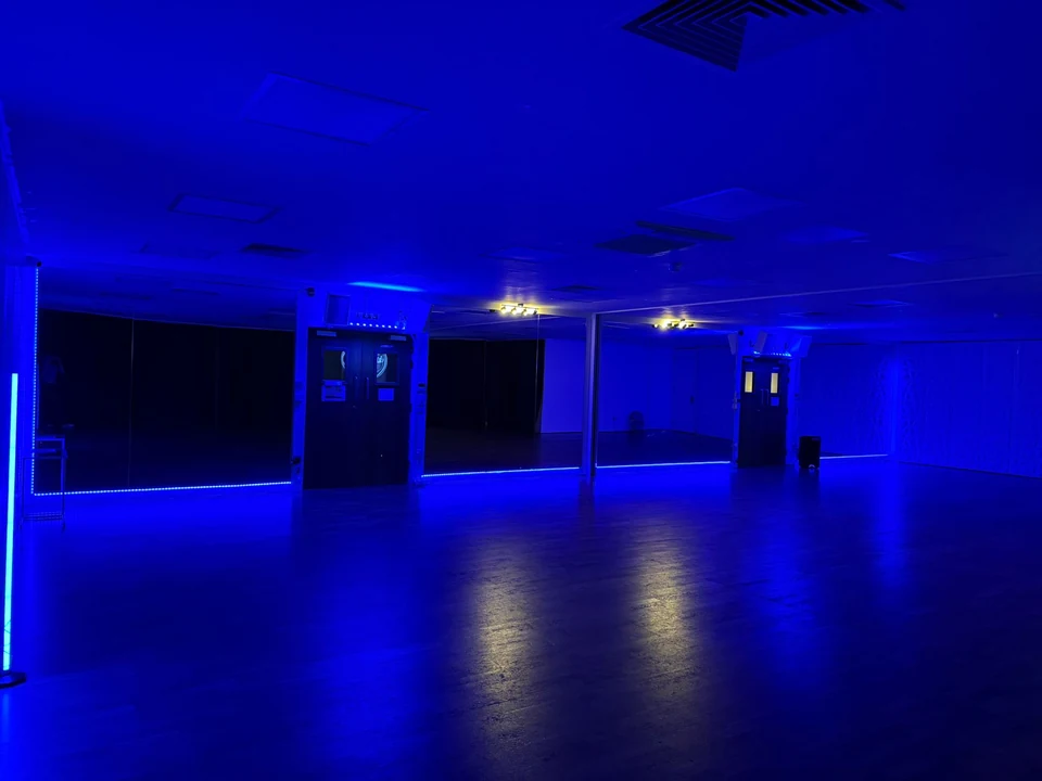 Dance studio with blue lighting and mirrors
