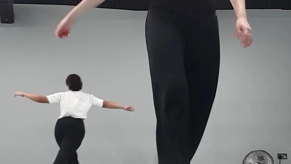 Two dancers practicing in a studio space