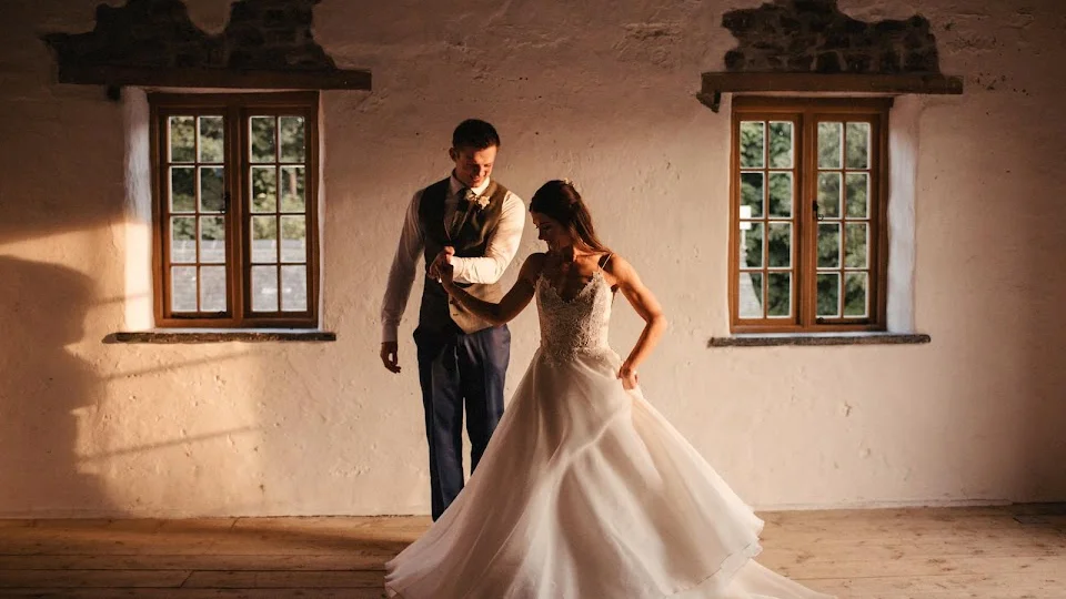 Couple dancing in a rustic venue with natural light