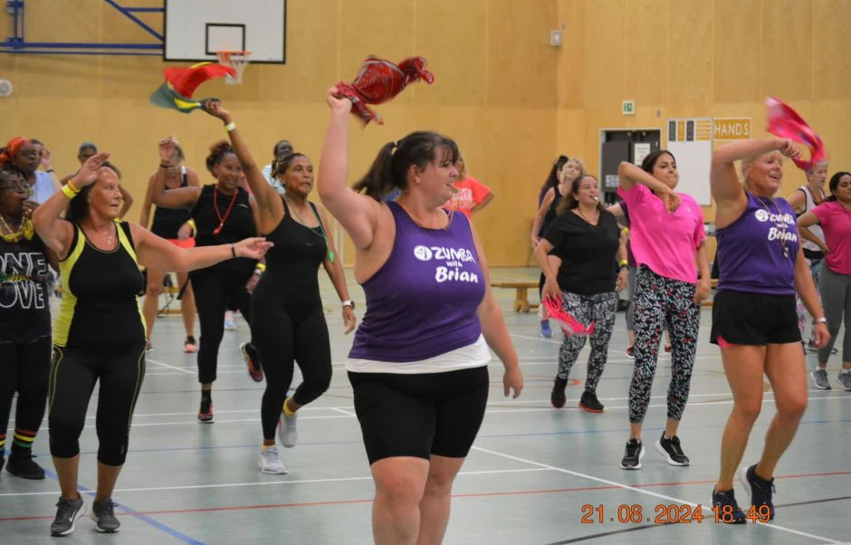 Zumba class in a gym with participants dancing